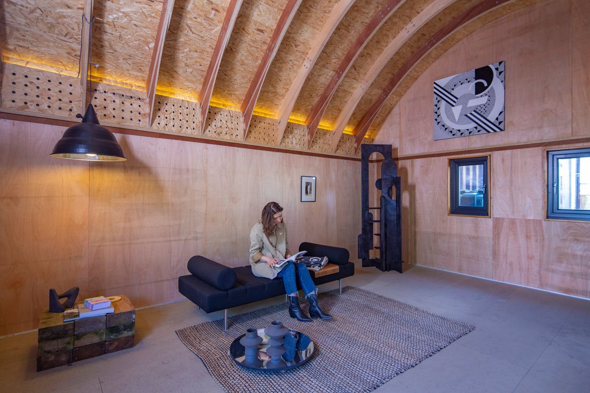 Wider view: reading on the daybed under the arched ply ceiling with its warm strip lighting