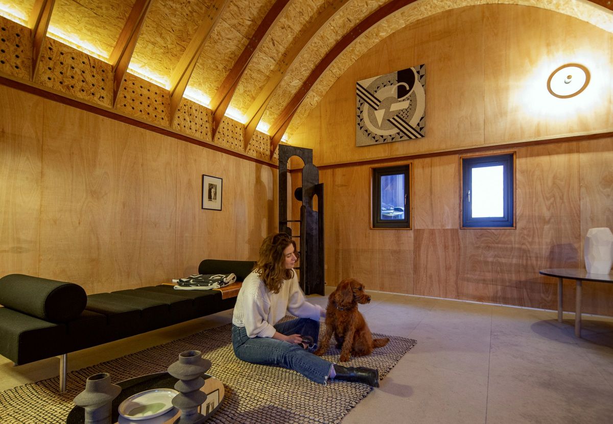 Woman sitting on the rug with her dog in the barn-style studio