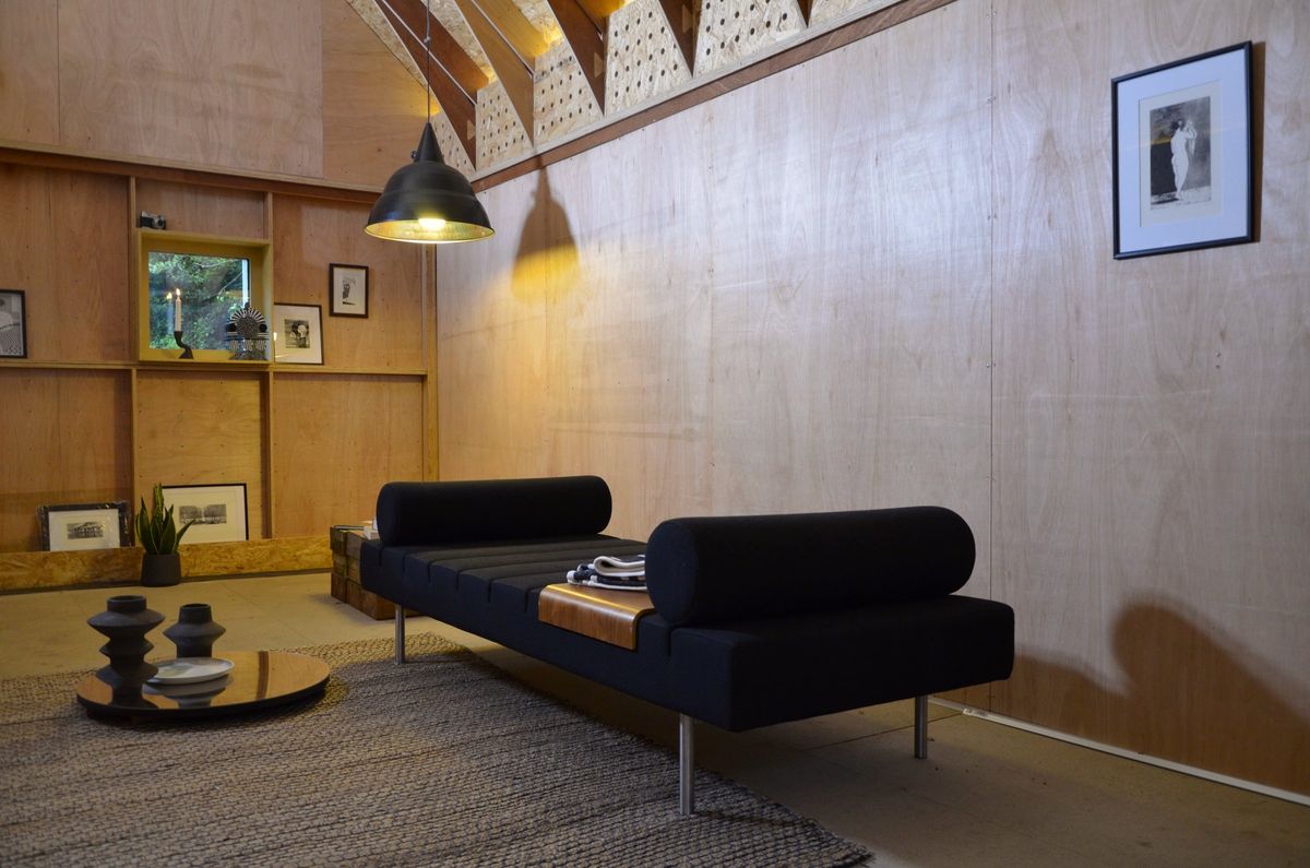 Black daybed and side table under a wall of framed prints