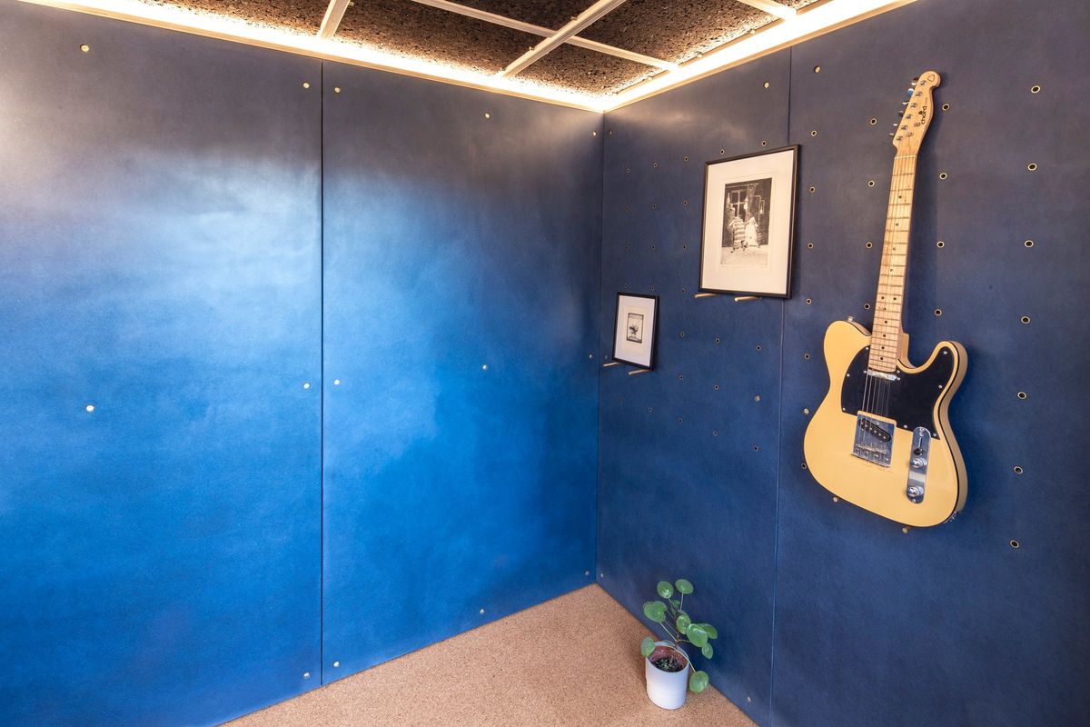 Corner with the guitar on the wall and framed photos