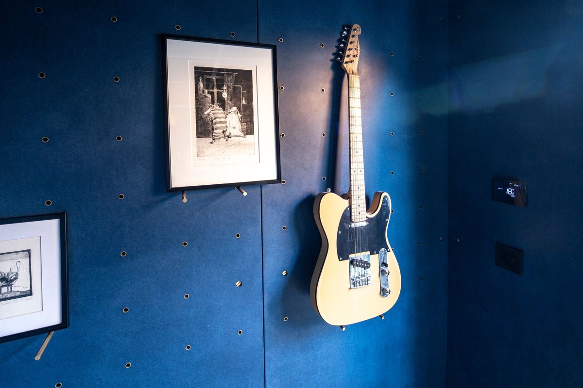 Electric guitar and framed photos on the blue wall