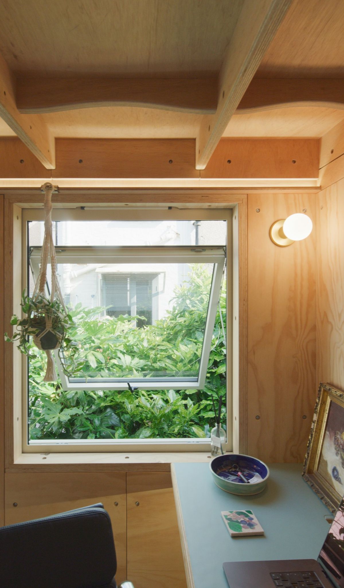 Top-hung window over the desk, garden beyond