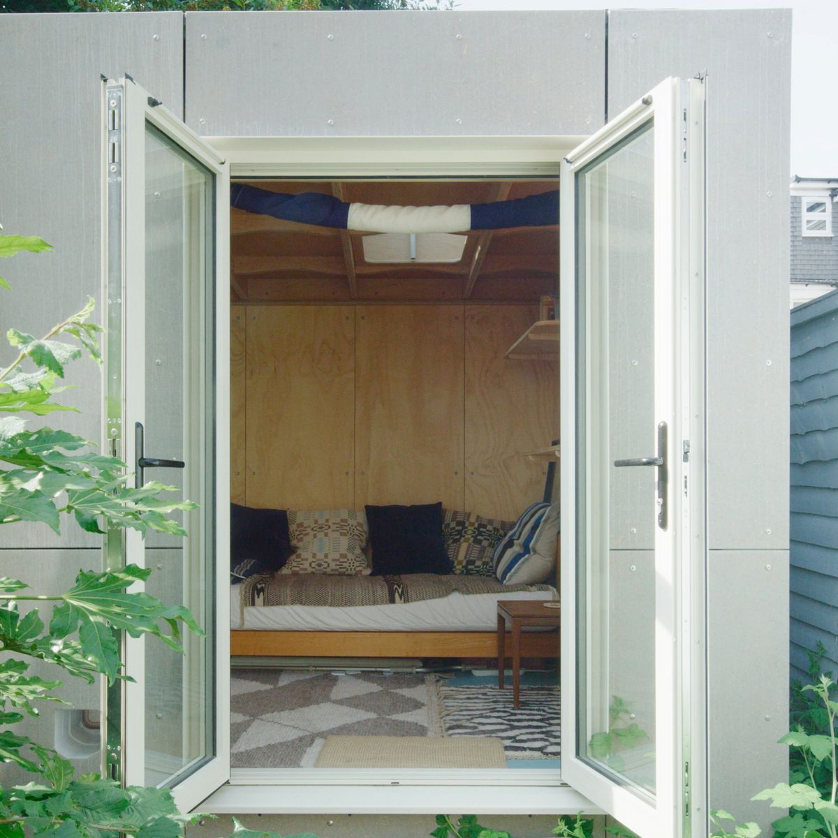 French doors open onto the sofa bed inside the garden studio