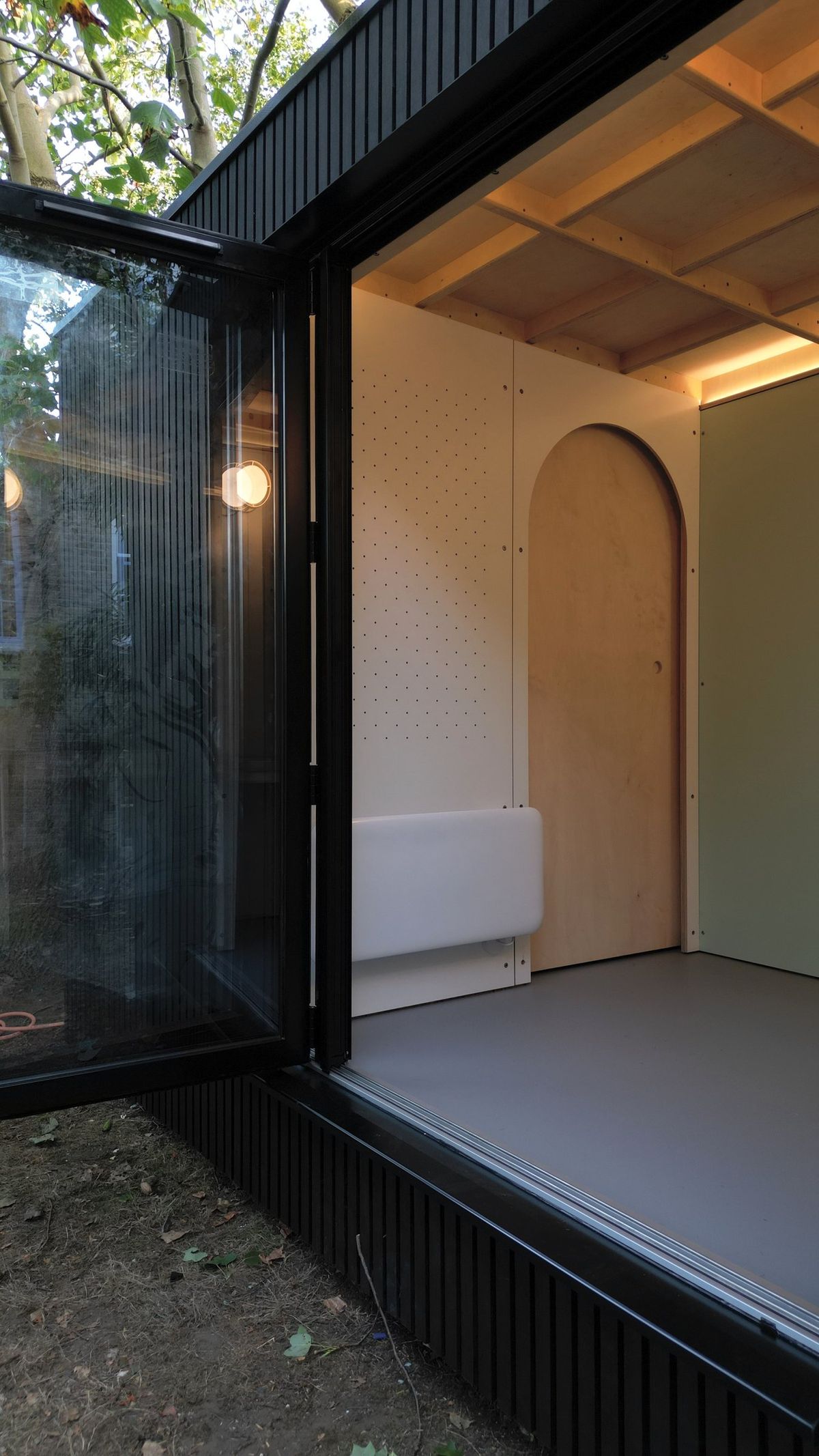 Folding door open onto the arch, peg wall and wall light