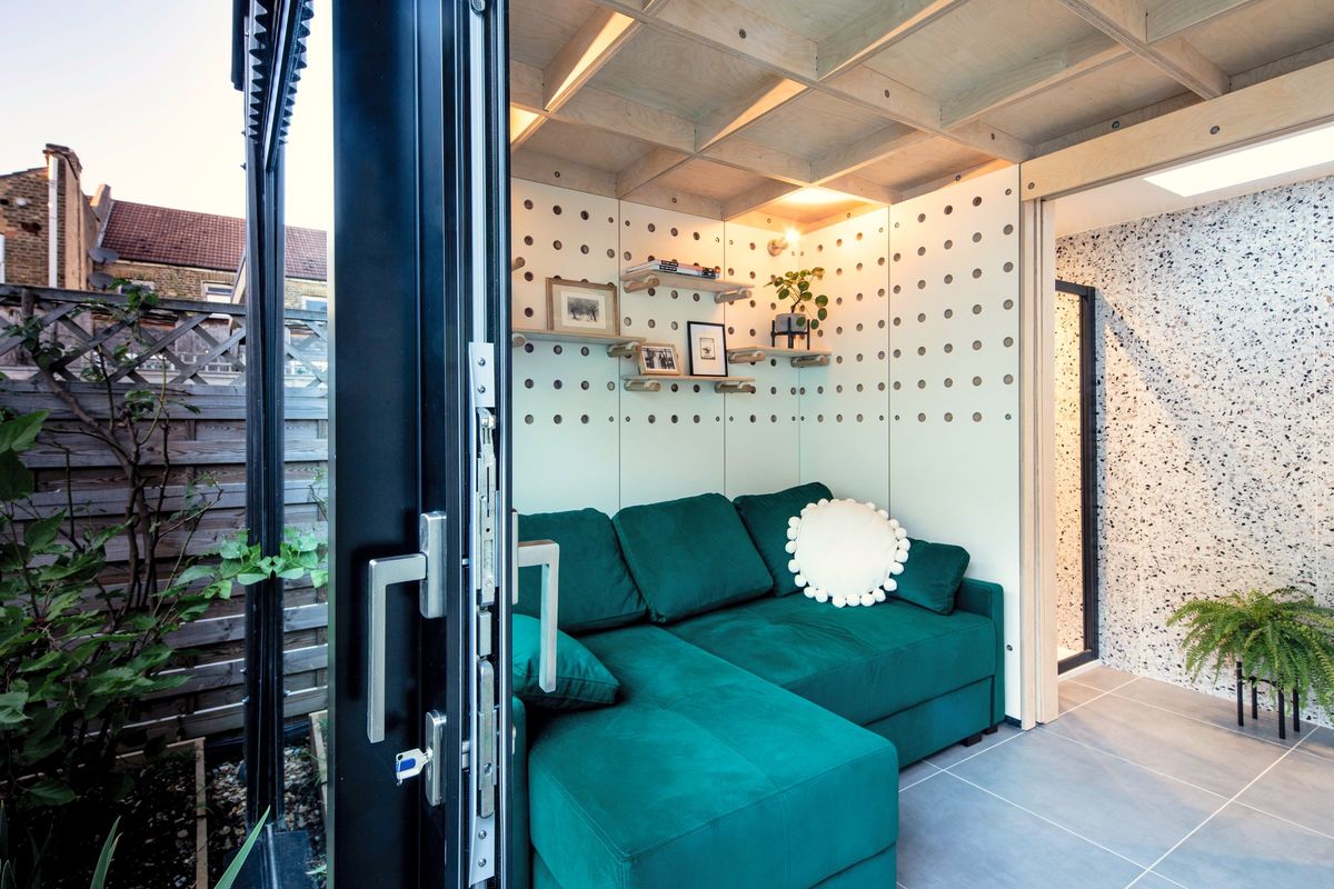Green sofa, peg shelves and terrazzo wall from the door