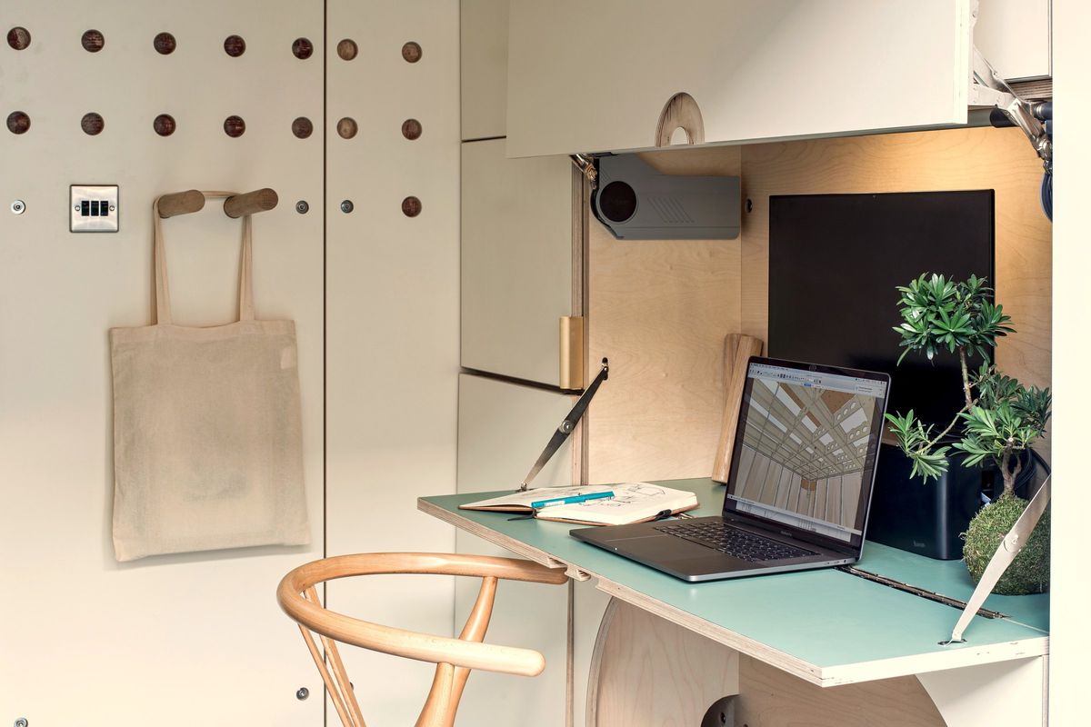 Fold-down desk with laptop, peg wall and wall storage