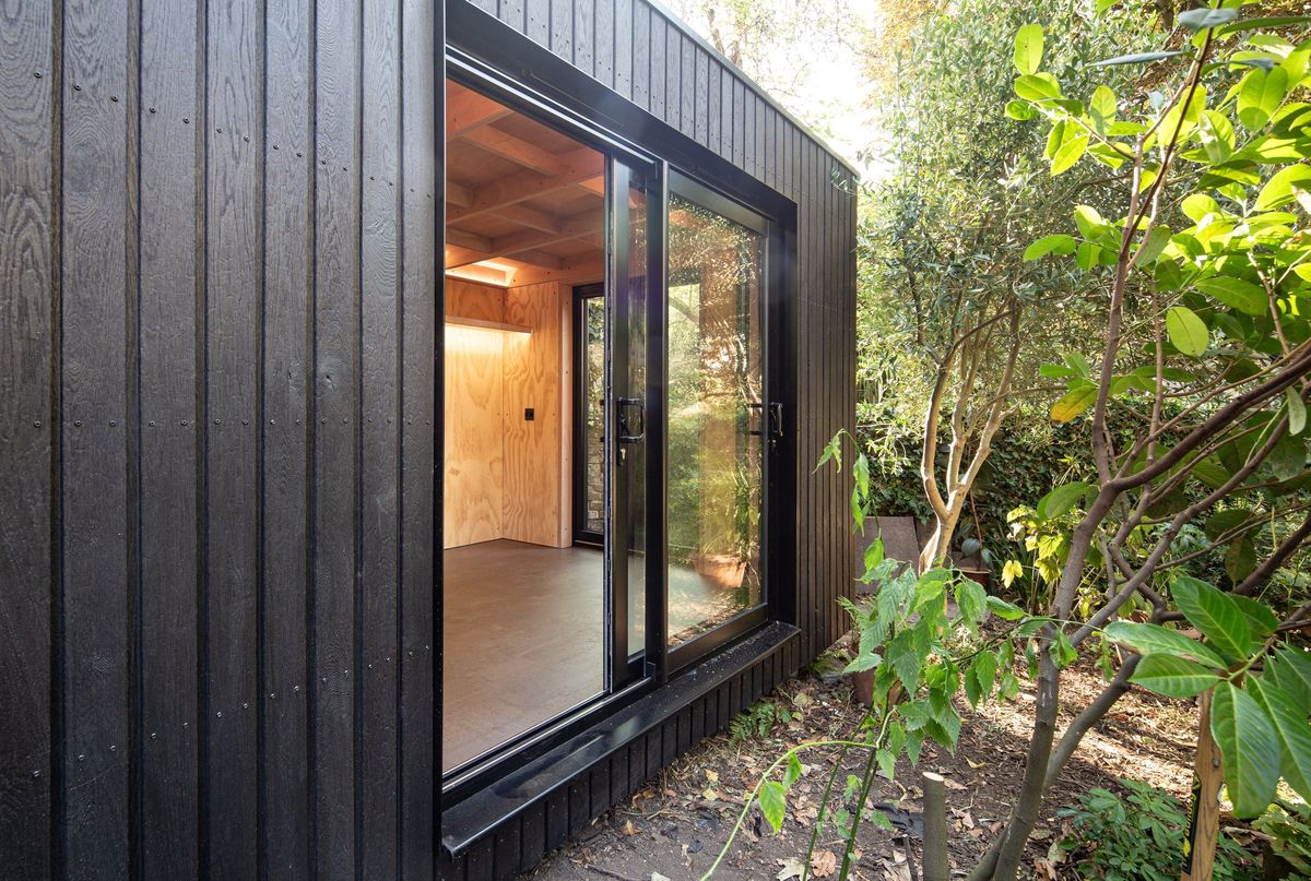 Corner view: sliding door open onto the plywood room