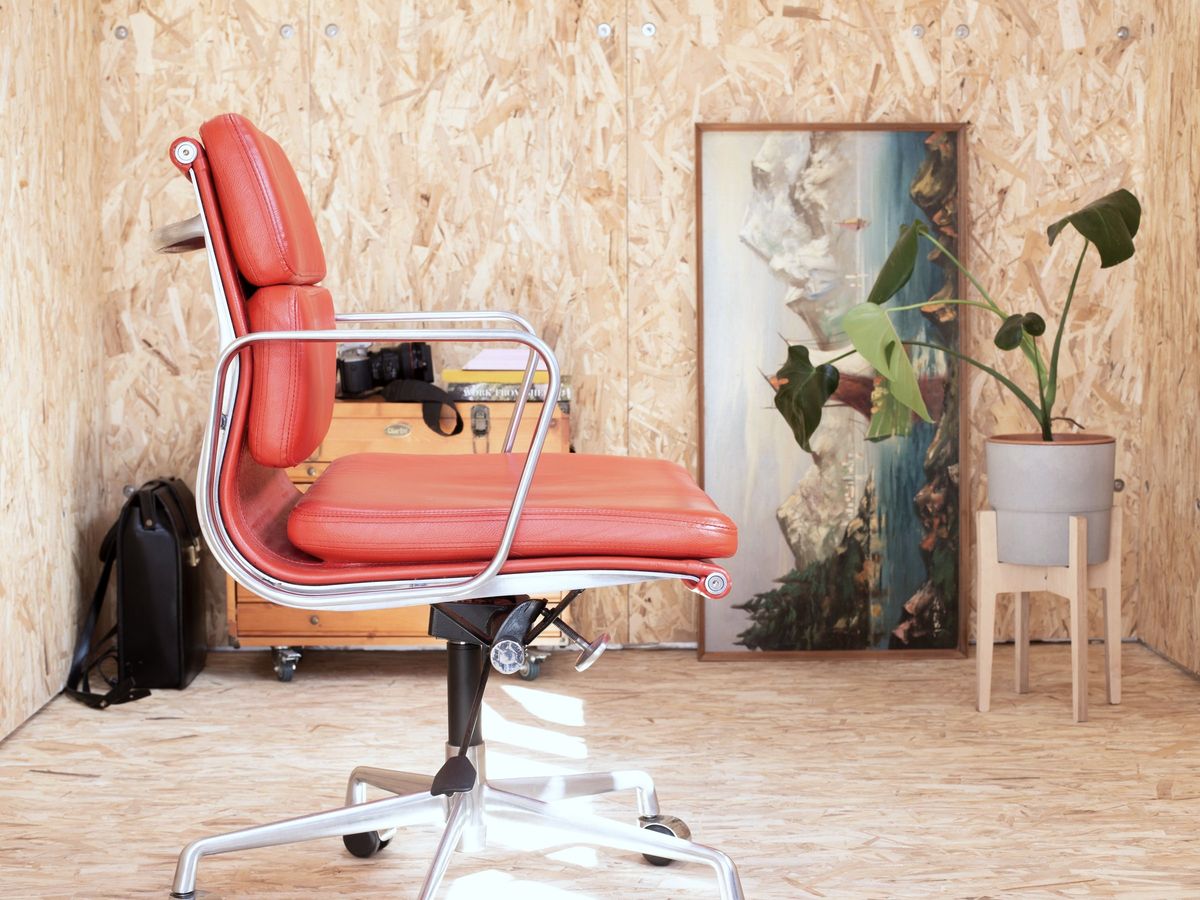 Red chair, painting and plant against the OSB wall