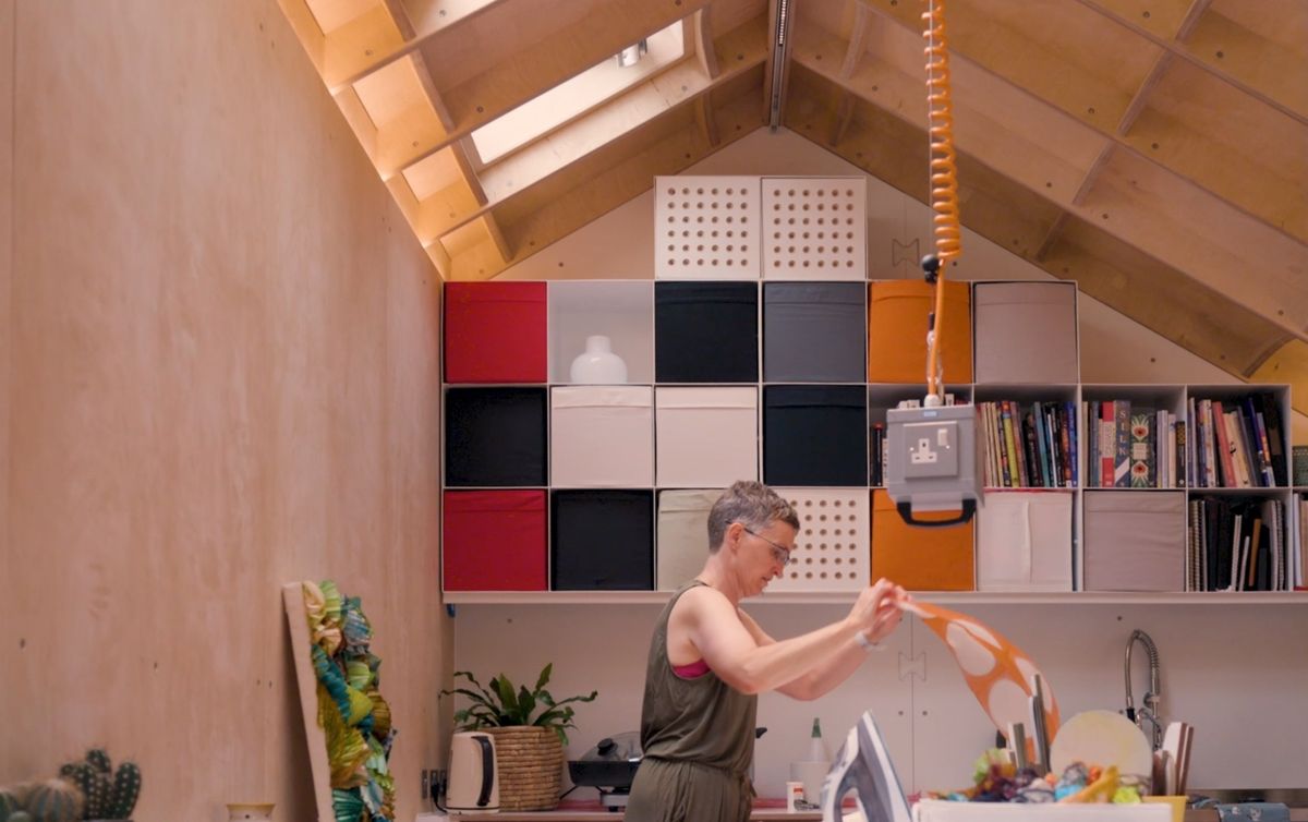 Working with fabric under the colourful storage wall