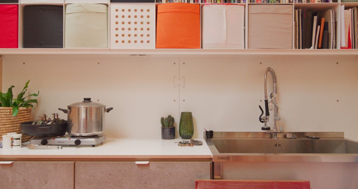 Kitchenette with a sink and hob, colourful cube storage above