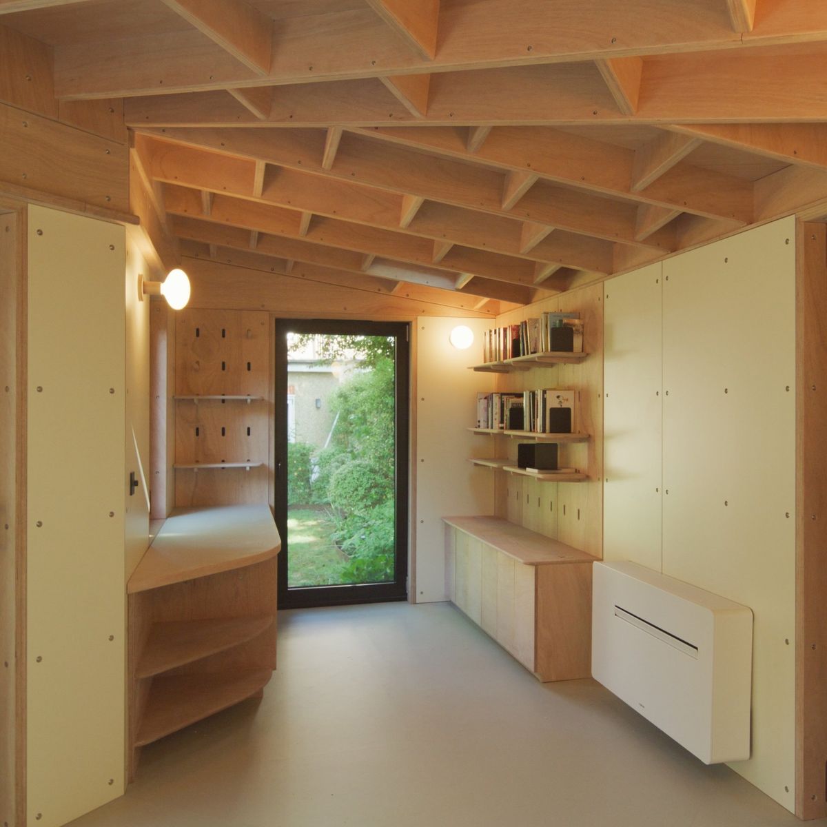 Down the length of the studio: built-in storage, peg wall and garden door