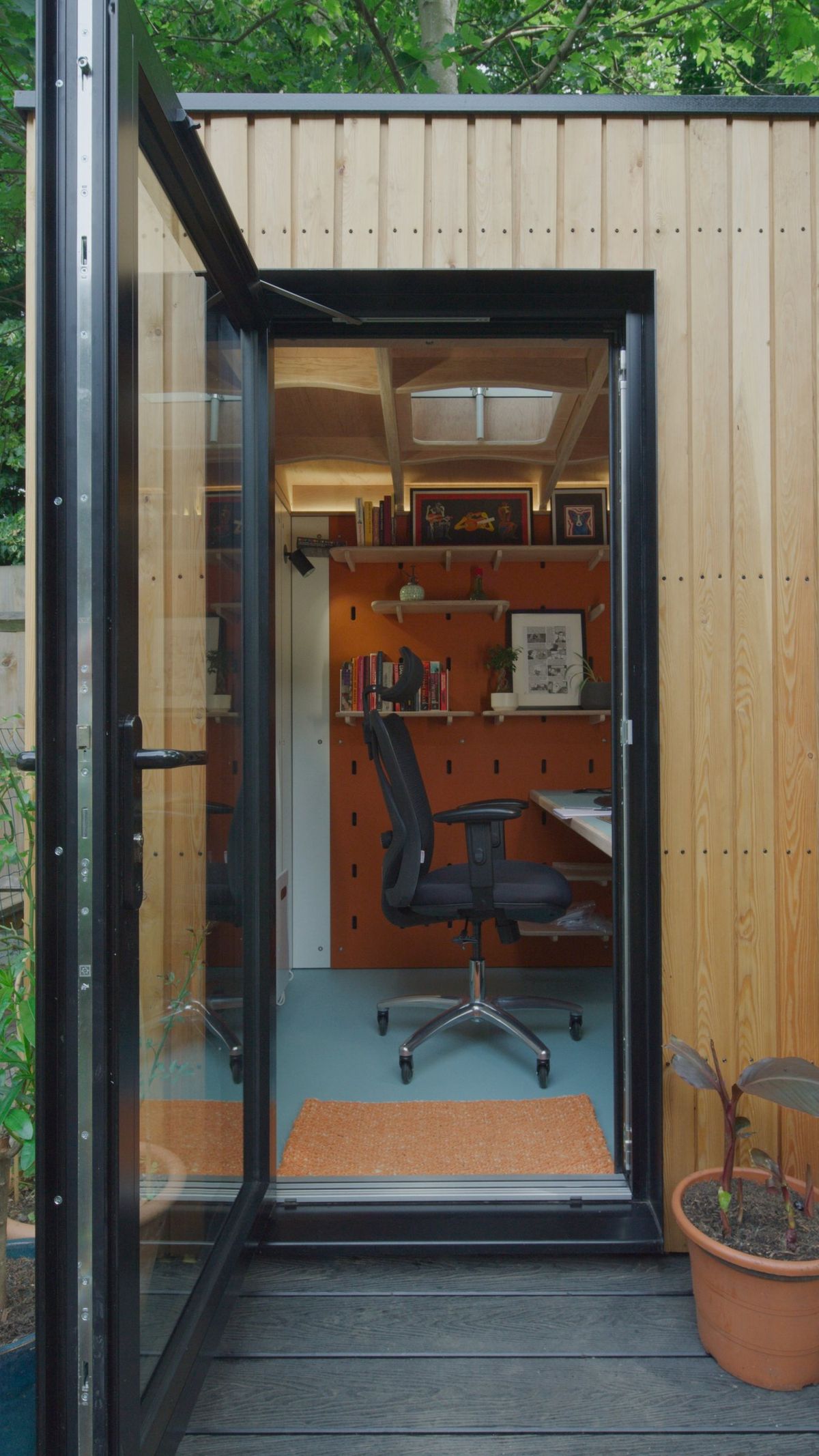 Through the open door: chair, desk and peg wall