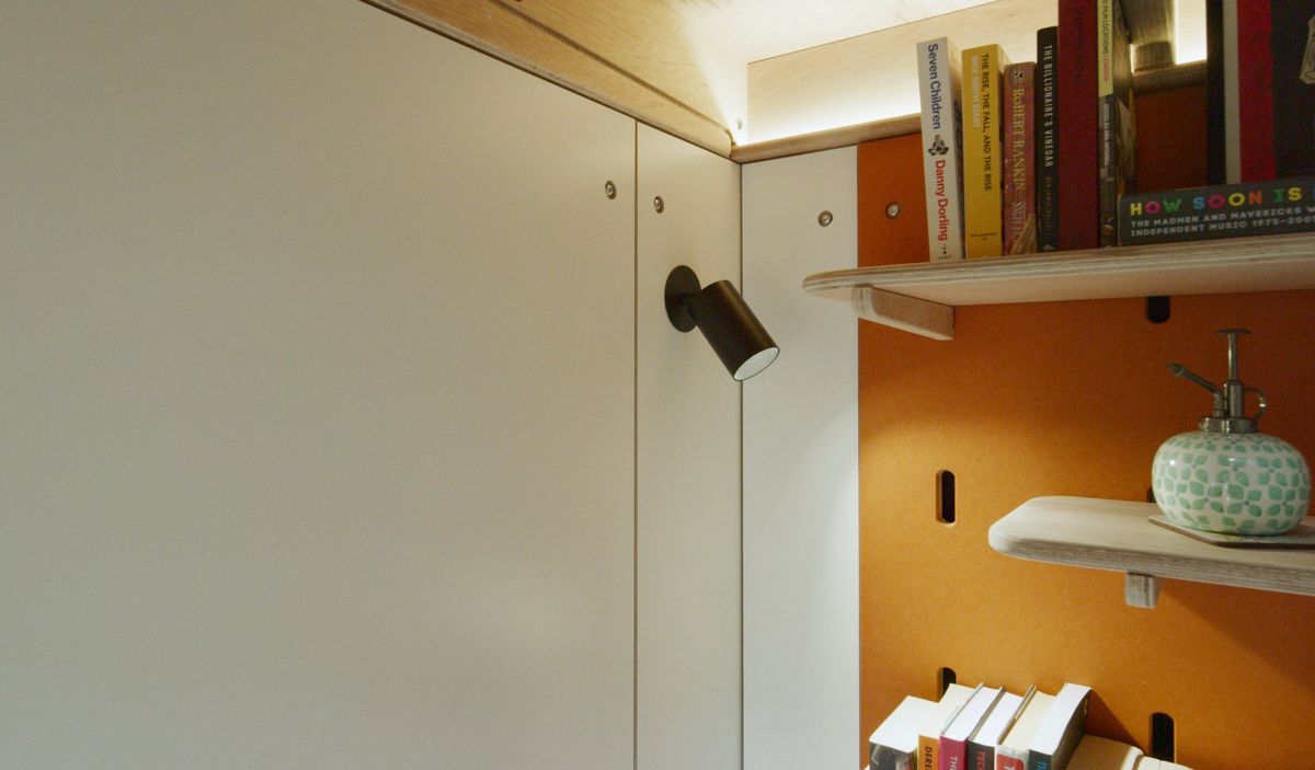 Orange peg wall with shelves and a spot lamp
