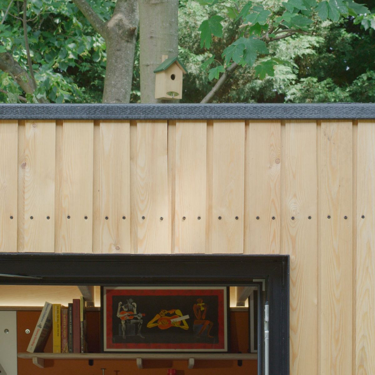 Natural larch boards over the window, art inside