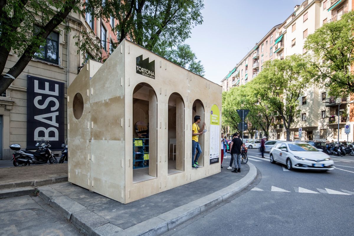 Quiubox, a plywood pavilion with arched openings on a street in Milan