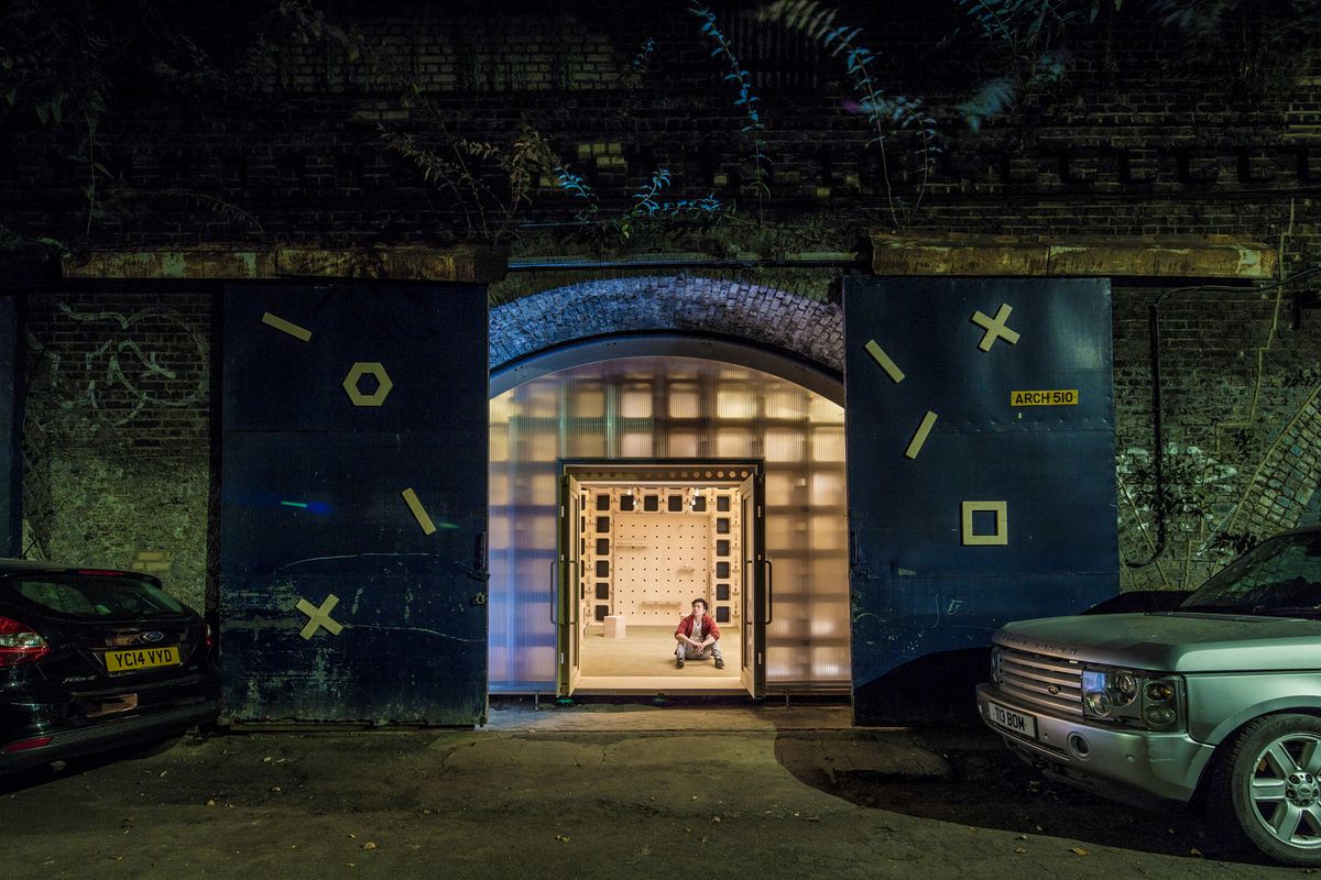 The Arches Project at night: a lit plywood workspace inside a London railway arch