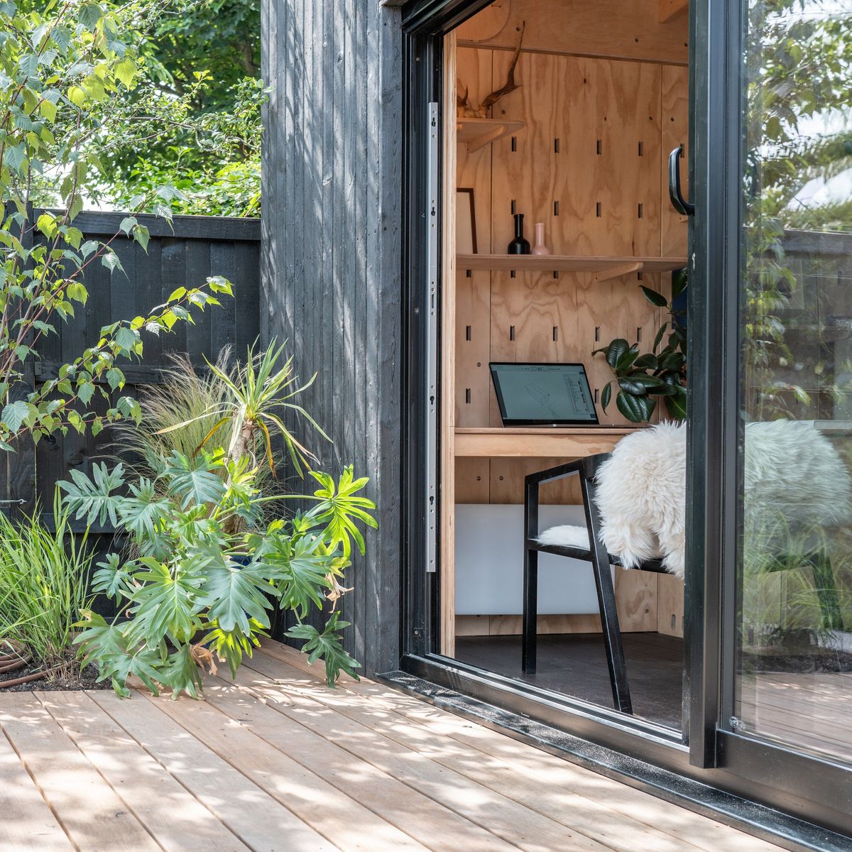 Open sliding door looking into the garden studio’s desk area from the deck