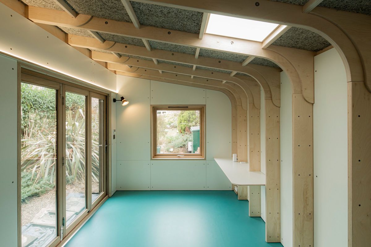 Arched ply frames, skylight, oak doors and the teal floor