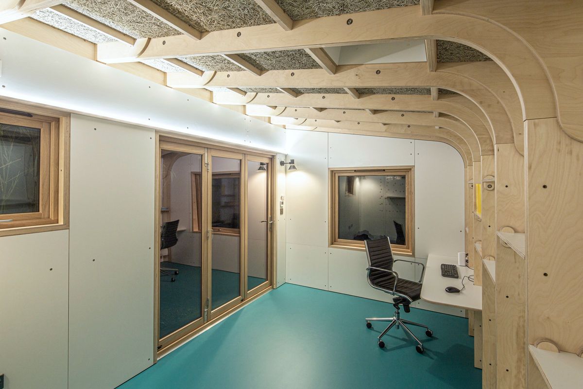 Desk, chair and glazed doors under the wood-wool ceiling