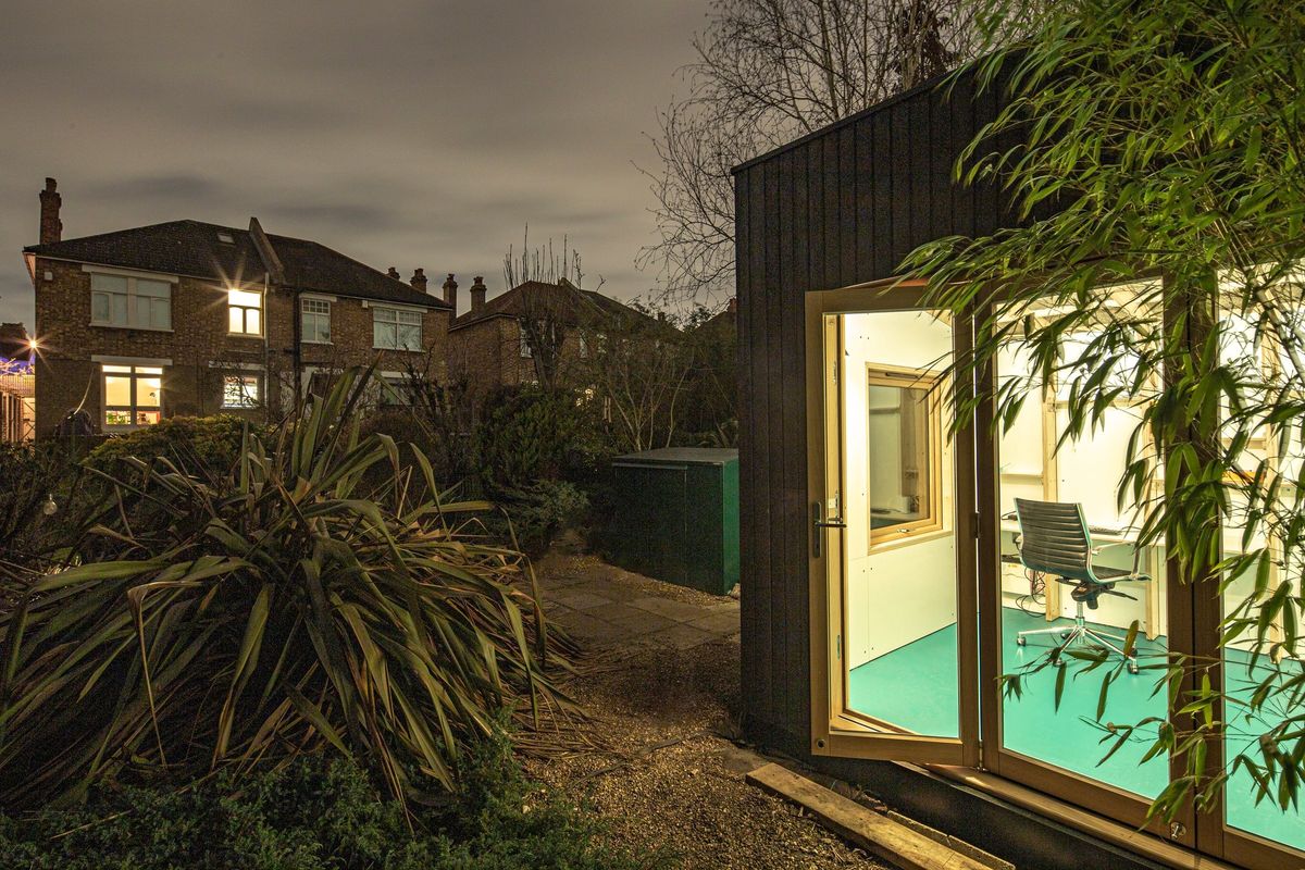 Lit studio at night, door open onto the desk