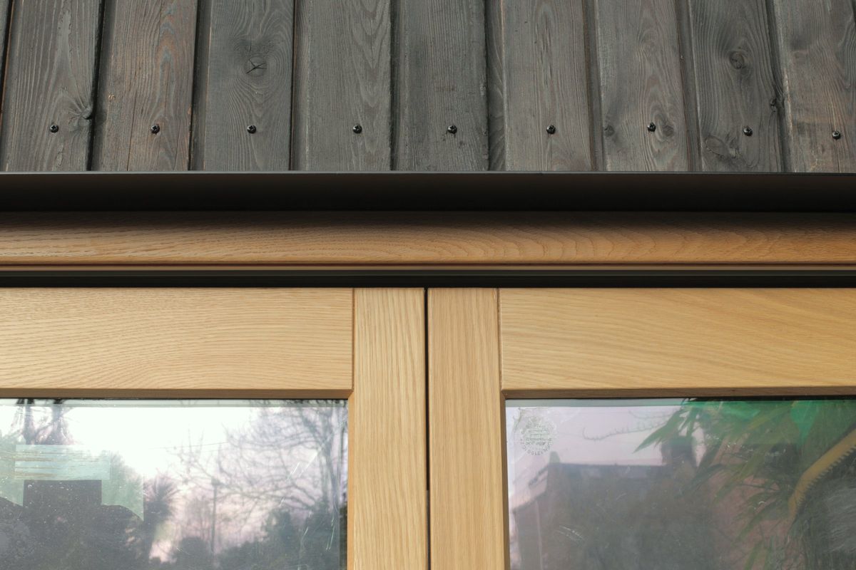 Oak window frame under the charred larch cladding