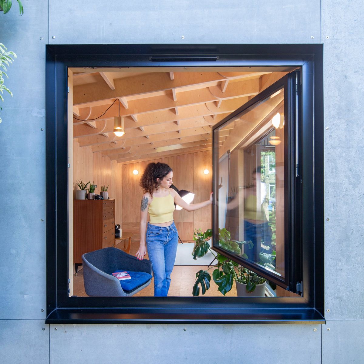 The large pivot window opened, the room seen through it