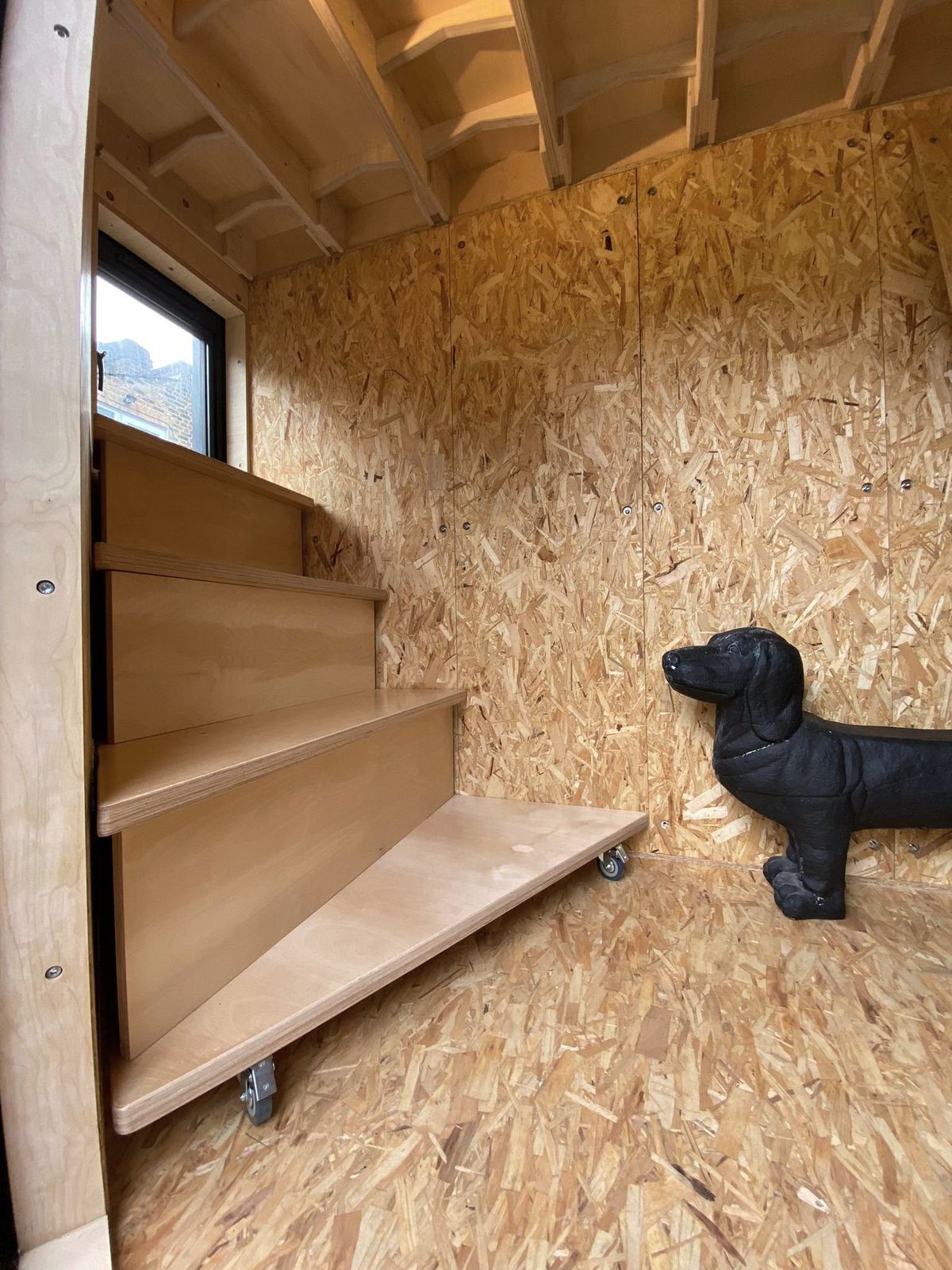 Ply steps and OSB walls, a dog sculpture in the corner