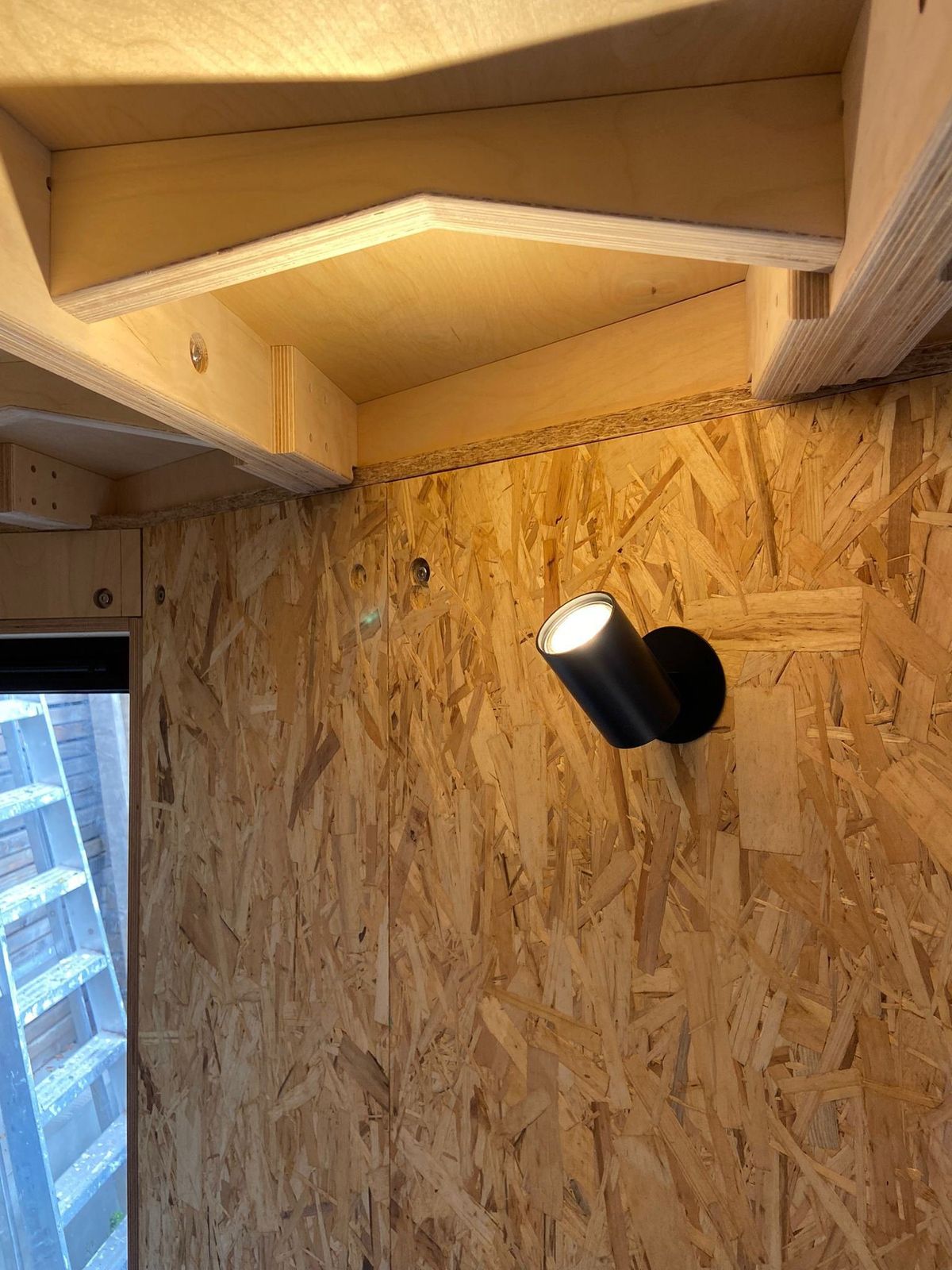 Black wall light on the OSB wall under the ply ceiling joists