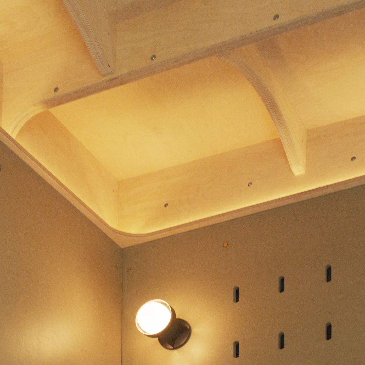 Lit plywood ceiling ribs over the peg wall