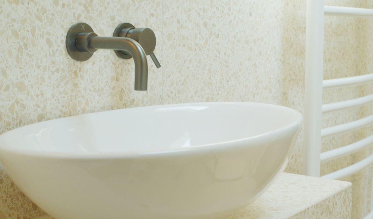 Bowl basin, brushed tap and terrazzo tiles in the en suite shower room